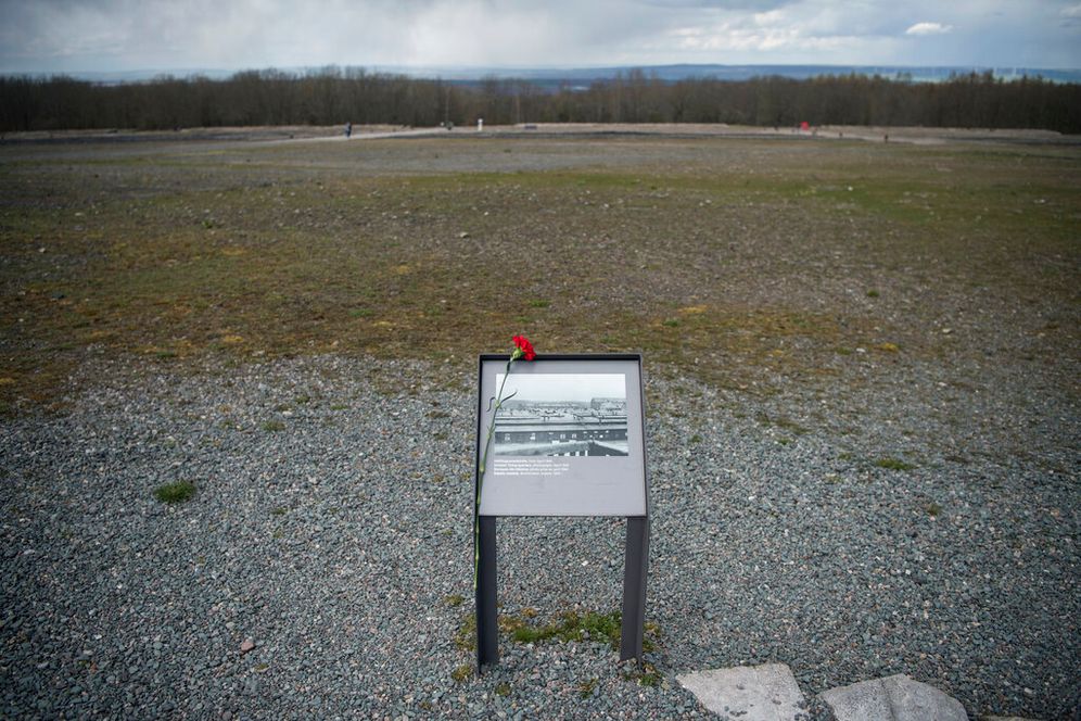 Panneau d'information avec une photo des quartiers des prisonniers lors d'une cérémonie marquant le 77e anniversaire de la libération du camp de concentration nazi de Buchenwald près de Weimar, en Allemagne, le 10 avril 2022