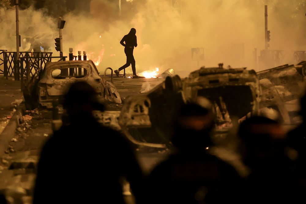 A demonstrator runs on the third night of protests sparked by the fatal police shooting of a 17-year-old driver in the Paris suburb of Nanterre, France.