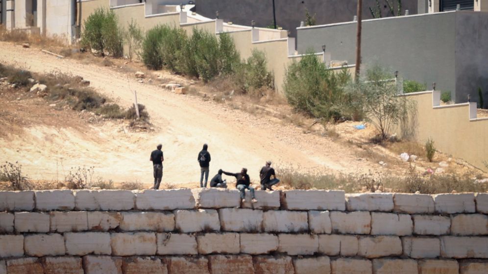 Israeli settlers gather in front of Palestinian houses in the West Bank village of Qusra, August 13, 2026