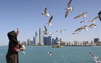 A woman feeds seagulls in the United Arab Emirates city of Abu Dhabi on January 24, 2022.