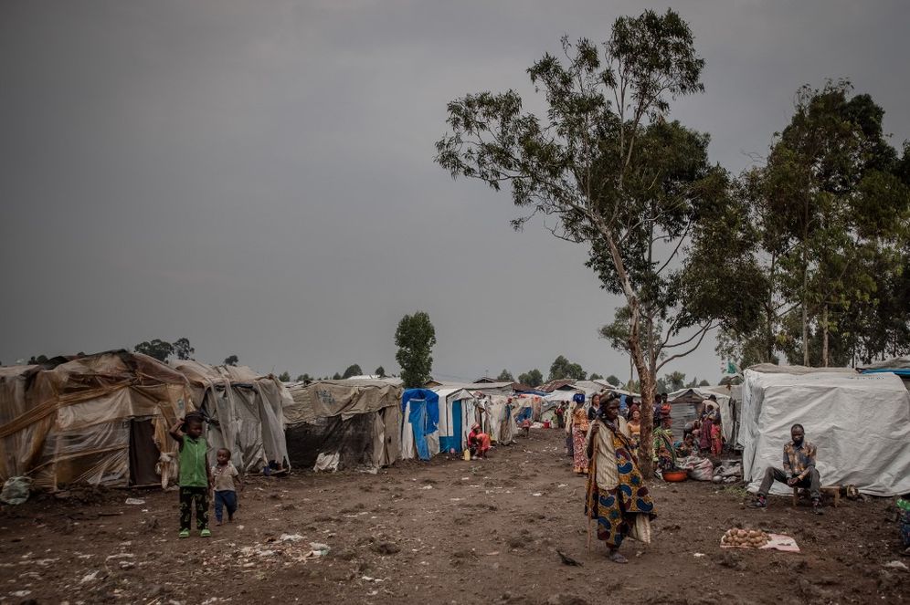 A woman walks in the courtyard of the Kayembe camp for displaced people in the North Kivu province of the Democratic Republic of Congo, on August 30, 2021.