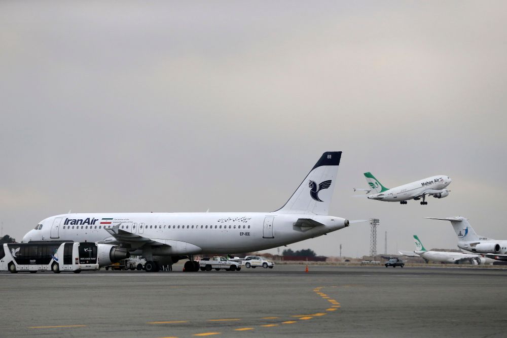 February 7, 2016, an Iranian Mahan Air passenger plane takes off as a plane of Iran's national air carrier, Iran Air, is parked at left, at Mehrabad airport in Tehran, Iran