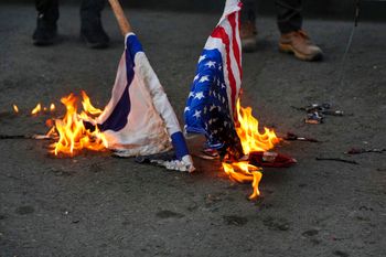 A group of hardline students burn the U.S. and Israeli flags in Tehran, Iran.