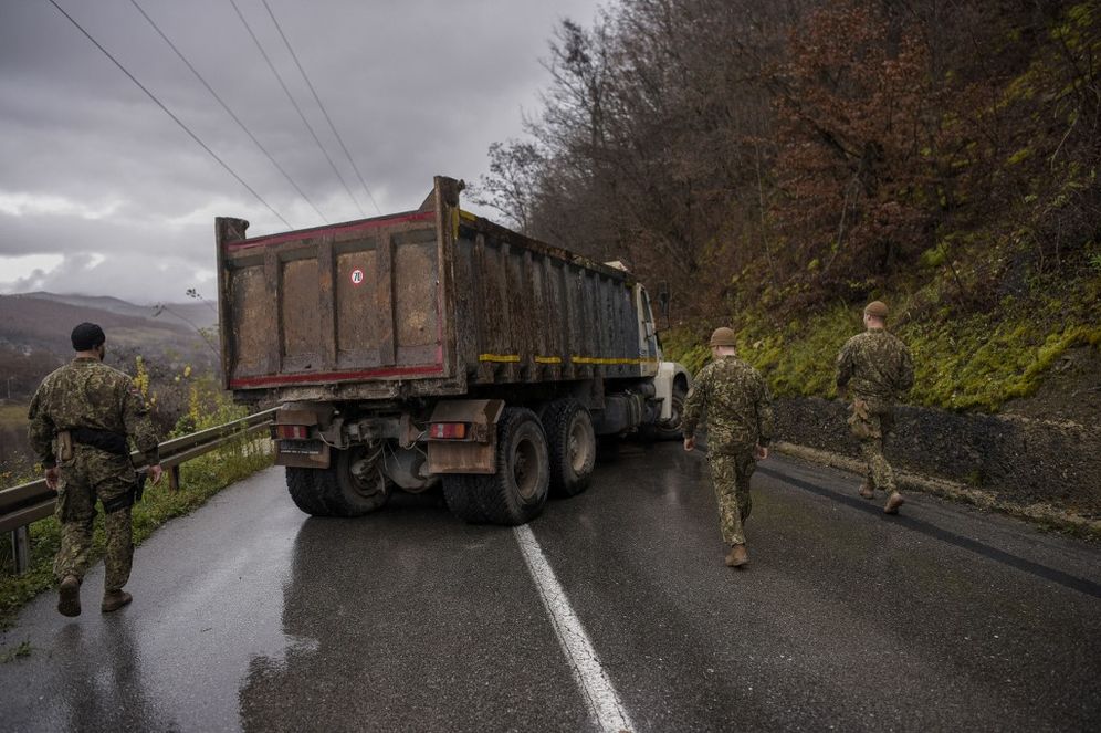NATO soldiers serving in the peacekeeping mission in Kosovo inspect a road barricade set up by ethnic Serbs near the town of Zubin Potok, Kosovo, on December 11, 2022.