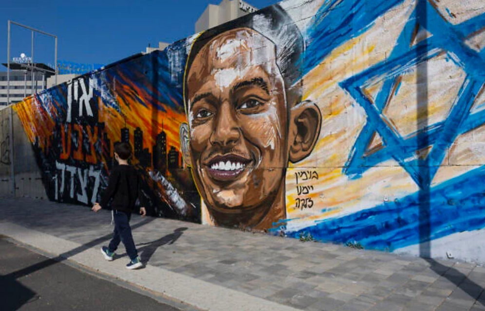 Un enfant passe devant une fresque commémorative en hommage à Yemanu Zelka, poignardé à mort à Petah Tikva lors de la fête de l’Indépendance une semaine plus tôt, à Ashdod, le 28 avril 2026. 