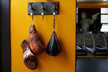 A set of boxing gloves hang on a wall.