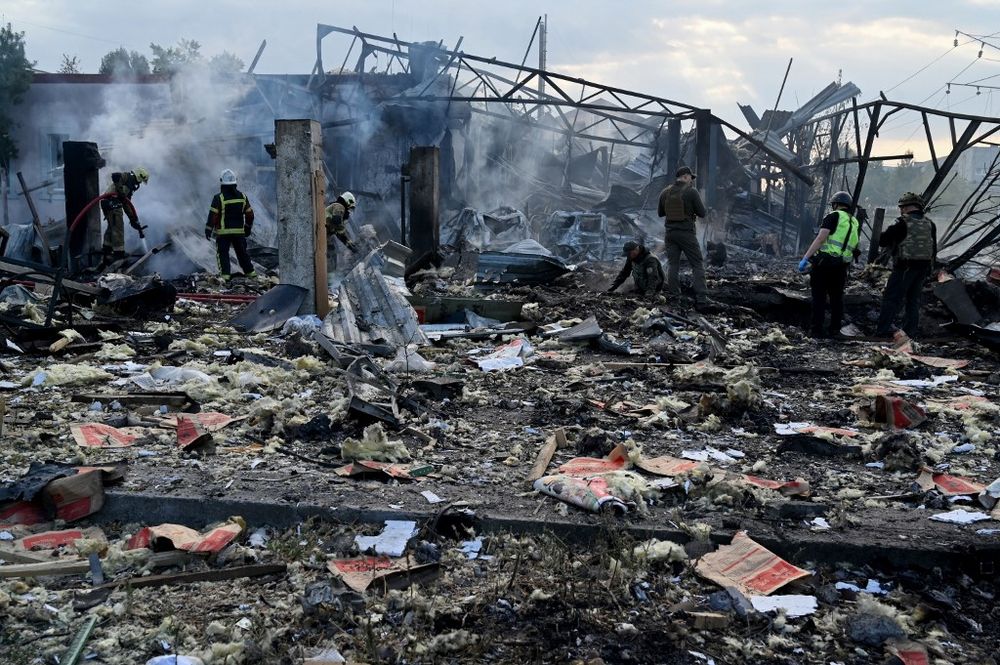 Firefighters push out a fire as police experts look for fragments of missile at a crater on an industrial area of the Ukrainian capital of Kyiv, after a massive overnight missile attack to Ukraine.