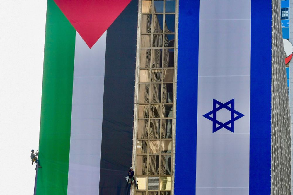 Deux gigantesques drapeaux - israélien et palestinien - le long du bâtiment de la Bourse du diamant à Ramat Gan, le 1er juin 2022