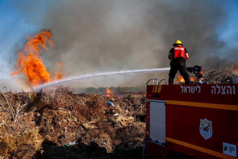 Firefighters try to distinguish a fire in the Simhoni forest caused by incendiary ballons sent by Palestinian terrorists into southern Israel. June 15, 2021.
