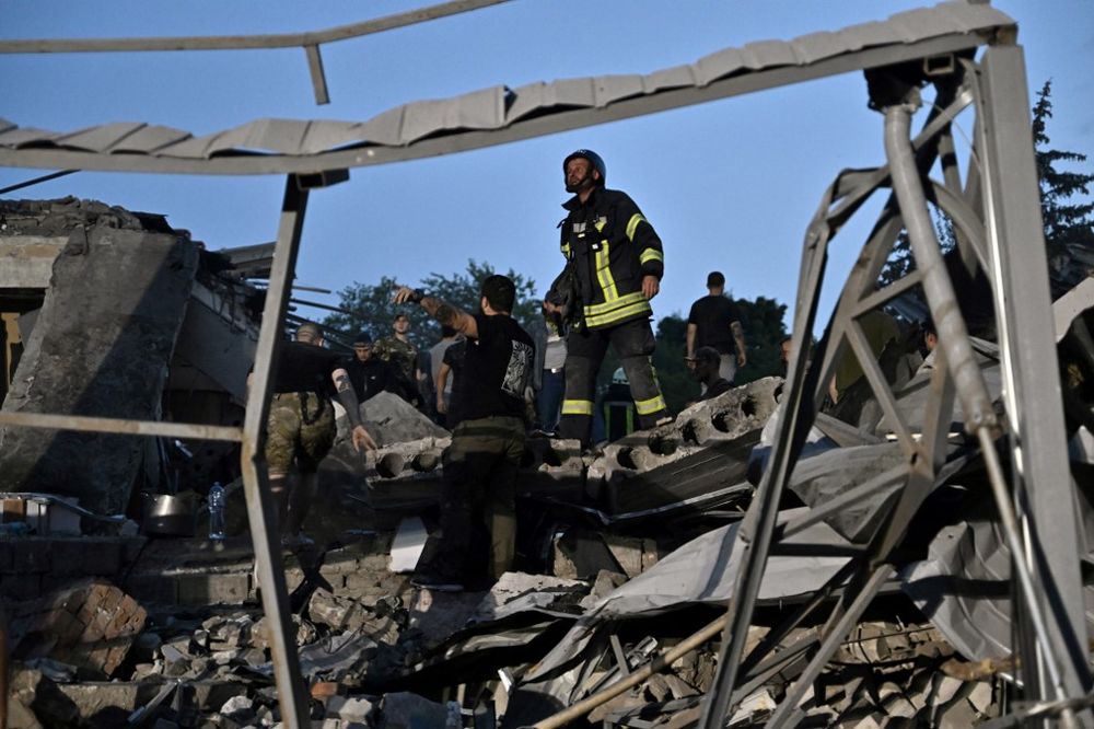 Rescuers and volunteers work to rescue people from under the rubble after a missile strike hit a restaurant in Kramatorsk, eastern Ukraine