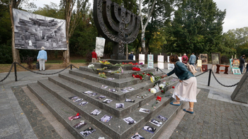 A woman lays flowers at a menorah monument close to a Babi Yar ravine where tens of thousands of Jews were killed during WWII, in Kyiv, Ukraine, September 29, 2020.