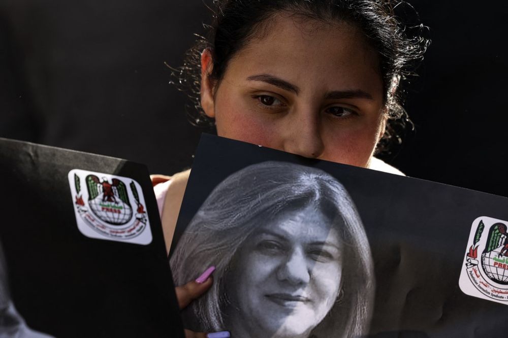 A Palestinian woman holds a photograph of late Al Jazeera journalist Shireen Abu Aqleh,  in the West Bank city of Ramallah, on May 11, 2022.