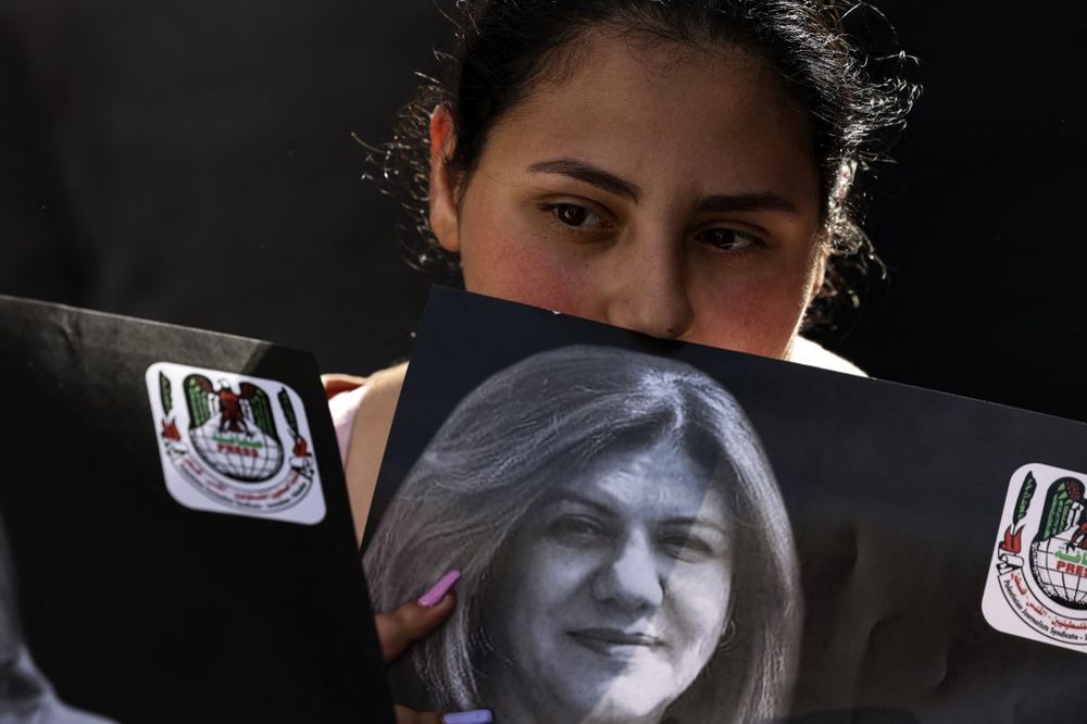 A Palestinian woman holds a photograph of late Al Jazeera journalist Shireen Abu Aqleh, in the West Bank city of Ramallah, on May 11, 2022.