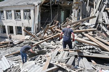 Workers of the Liubotinsky Lyceum of Railway Transport and local residents dismantle the ruins of an administrative building, as result of the explosion of a Russian rocket, in Lyubotyn, Kharkiv region, Ukraine, on June 20, 2022.