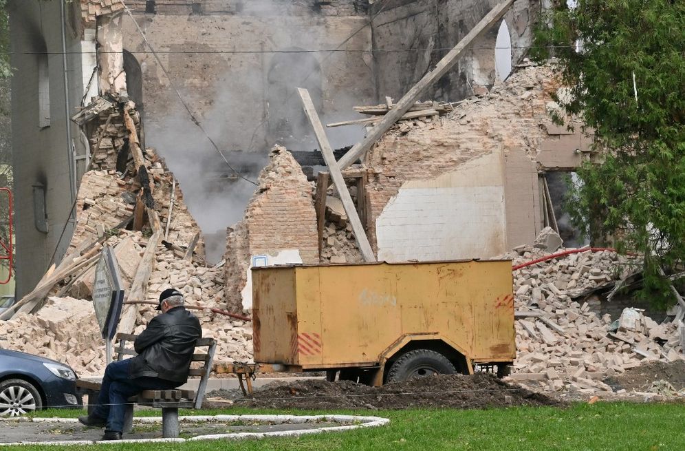 Sergei SUPINSKY / AFP A local resident sits outside a building destroyed by Russian, Iranian-made, drones after an airstrike on Bila Tserkva, southwest of Kyiv, on October 5, 2022, amid the Russian invasion of Ukraine.