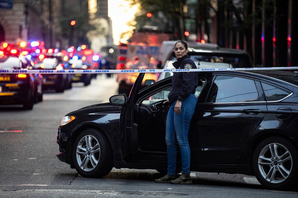 AP Photo/Angelina Katsanis A New York police investigator exits her vehicle at the scene outside a Manhattan office building where two people were shot including a police officer