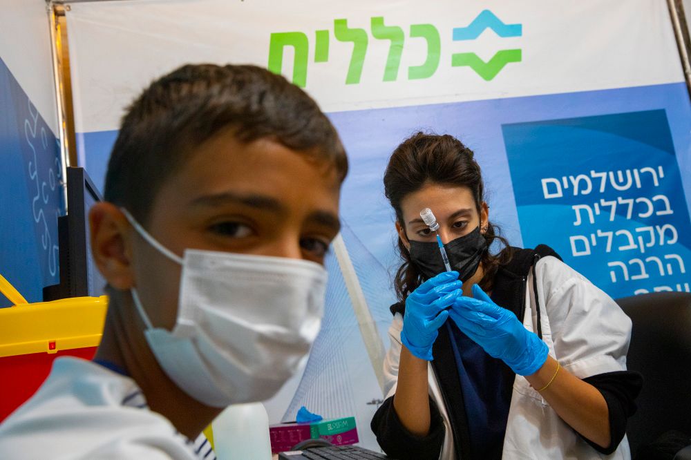 Un jeune Israélien reçoit sa troisième dose du vaccin anti- Covid-19 dans un centre de santé Clalit, le 20 septembre 2021 à Jérusalem.