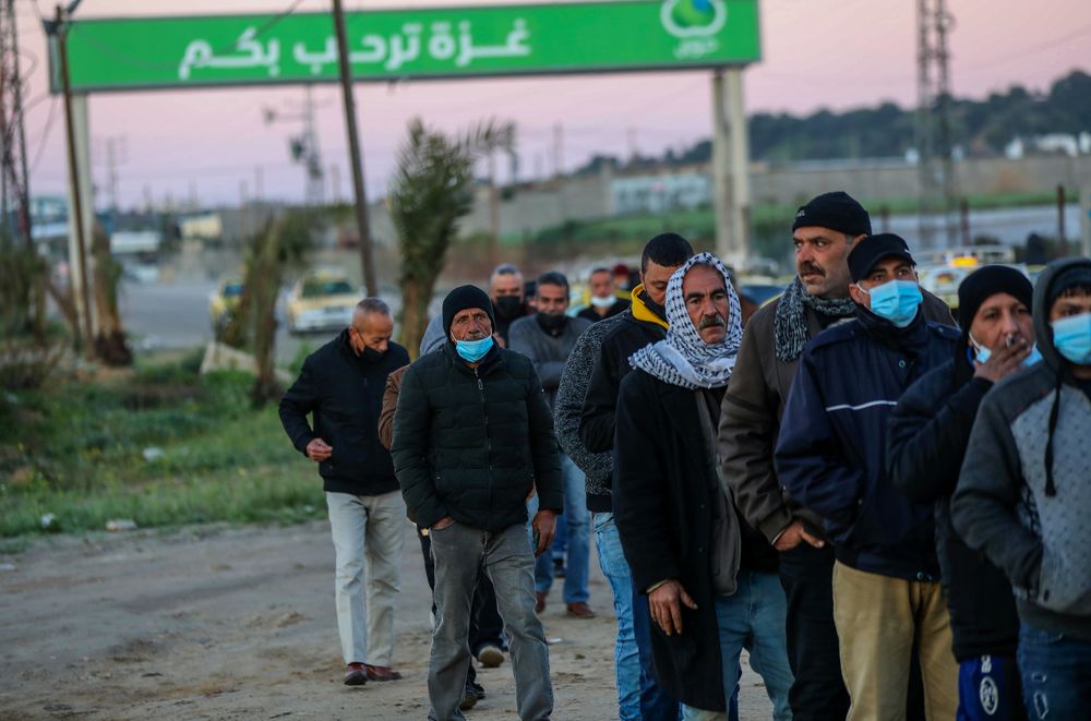 Palestinian workers que at the Erez crossing in Beit Hanun, in the northern Gaza Strip, as they wait to enter Israel for work, on March 13, 2022.