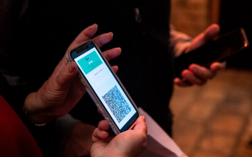 A woman shows her COVID-19 vaccination certificate upon arrival at a Jerusalem theater on February 23, 2021.