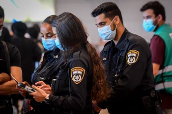 Israeli police officers enforce COVID-19 regulations at the Ben Gurion International Airport, on July 19, 2021.