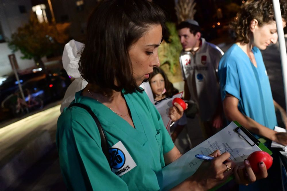 A medical intern signs a letter of resignation at a demonstration for better work conditions for medical interns, in Tel Aviv, Israel, on October 9, 2021.