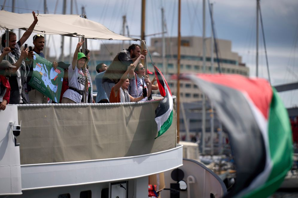 Swedish climate activist Greta Thunberg waves from a boat taking part in a civilian flotilla bound for Gaza, aiming to break the Israeli blockade and deliver humanitarian aid, in Barcelona, Spain, Sunday, Aug. 31, 2025