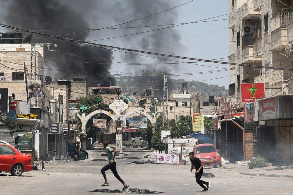 Des jeunes Palestiniens se mettent à l'abri lors d'une opération militaire israélienne dans la ville de Jénine, en Cisjordanie, le 3 juillet 2023