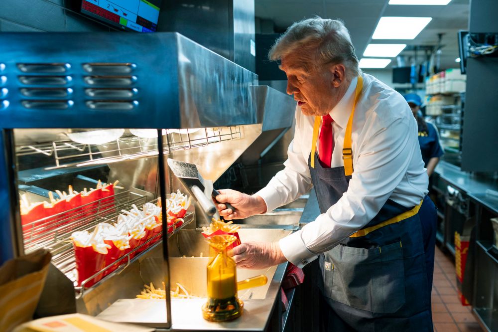 يRepublican presidential candidate, former U.S. President Donald Trump, works behind the counter during a visit to a McDonald's restaurant on October 20, 2024 in Feasterville-Trevose, Pennsylvania.