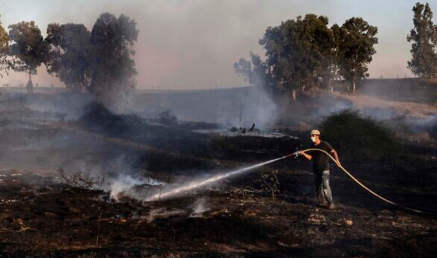 Illustration - Un Israélien tente d'éteindre un incendie du côté israélien de la frontière entre l'Etat hébreu et Gaza, le 21 août 2020.
