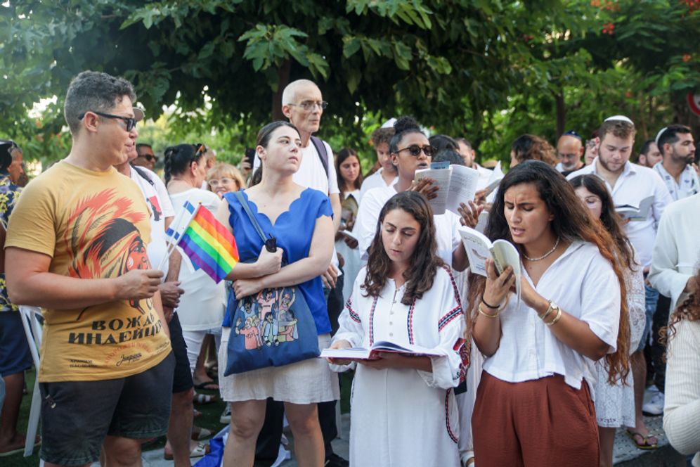 Des Juifs prient pendant que des militants protestent contre la ségrégation sexuelle dans l'espace public, lors d'une prière publique sur la place Dizengoff à Tel Aviv, à l'occasion de Yom Kippour, le Jour des Expiations et la plus sainte des fêtes juives
