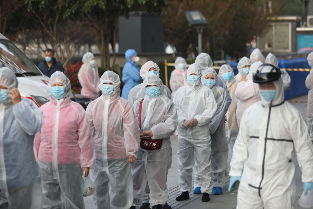 Des patients rétablis du coronavirus COVID-19 portent des vêtements de protection pour être testés à nouveau dans un hôpital de Wuhan, dans la province centrale du Hubei en Chine, le 14 mars 2020
