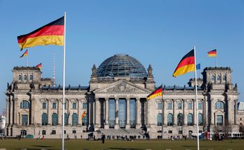 الأعلام الألمانية ترفرف أمام مبنى الرايخستاغ، الذي يستضيف البرلمان الاتحادي الألماني (البوندستاغ)، في برلين، ألمانيا، الثلاثاء، 5 مارس 2013.