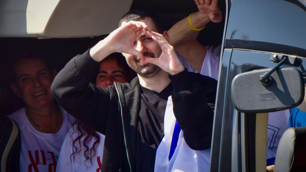 Released hostage Guy Gilboa-Dalal waves the Israeli flag as he arrives to Beilinson hospital, October 13, 2025. 