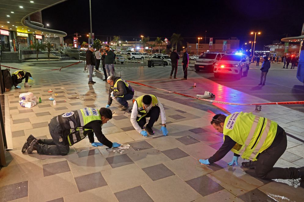 Des volontaires de Zaka, une équipe d'intervention d'urgence juive ultra-orthodoxe en Israël, sur les lieux d'une attaque au couteau devant un centre commercial à Beer Sheva, le 22 mars 2022