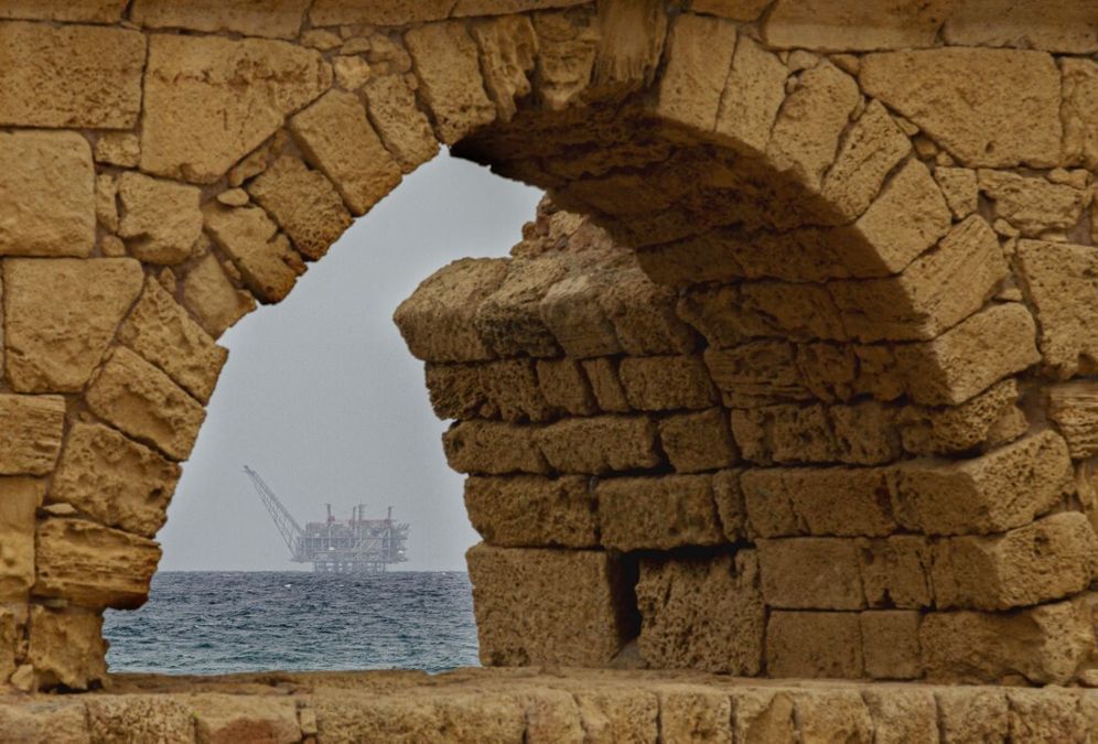 صورة لمنصة حقل ليفياثان للغاز الطبيعي في البحر الأبيض المتوسط من خلال موقع تاريخي في مدينة قيسارية الساحلية ، في 24 فبراير 2022.