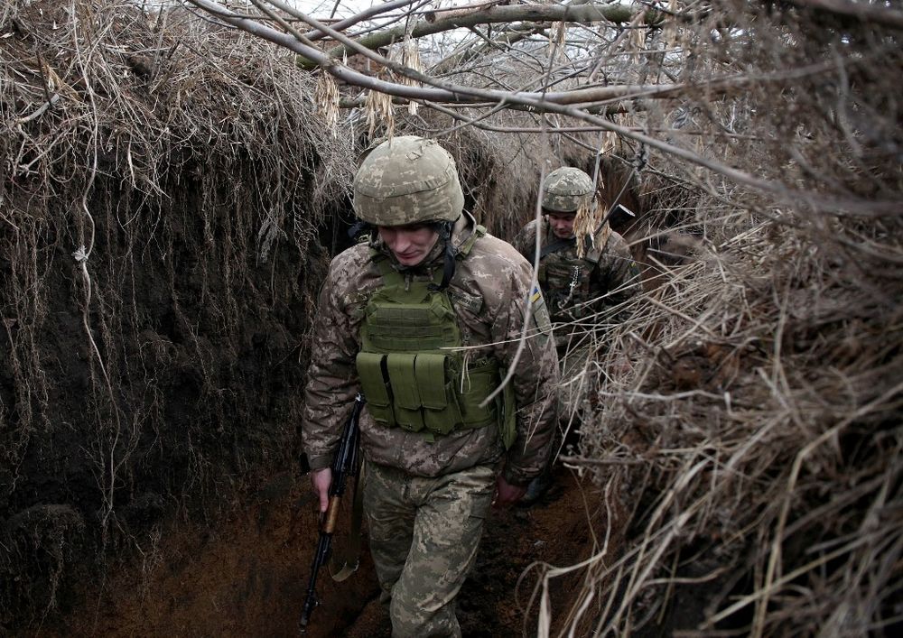 Des militaires ukrainiens marchent en gardant leur position sur la ligne de front avec les séparatistes soutenus par la Russie, près de Novolugansk, dans la région de Donetsk, le 17 février 2022.