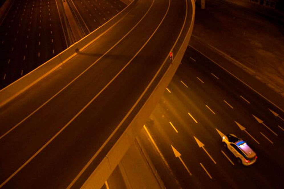 A lone police car travels down a 12-lane segment of Sheikh Zayed Road after a curfew in Dubai, United Arab Emirates, March 31, 2020.