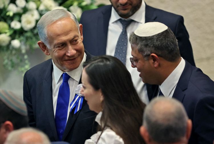 Israeli lawmaker Itamar Ben-Gvir (R) chats with incoming prime minister Benjamin Netanyahu (L) during the swearing in ceremony of the new Israeli government at the Knesset (Israeli parliament) in Jerusalem.