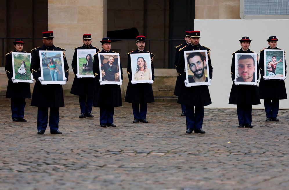 Gonzalo Fuentes/Pool via AP La Garde républicaine tient des portraits des victimes françaises de l'attaque du Hamas du 7 octobre 2023, lors d'une cérémonie au monument des Invalides, le mercredi 7 février 2024
