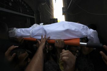 Mourners carry the body of Palestinian boy Najmeddin Najm during his funeral in Jabalia in the northern Gaza Strip on August 8, 2022.