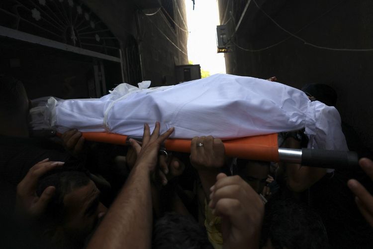 Mourners carry the body of Palestinian boy Najmeddin Najm during his funeral in Jabalia in the northern Gaza Strip on August 8, 2022.