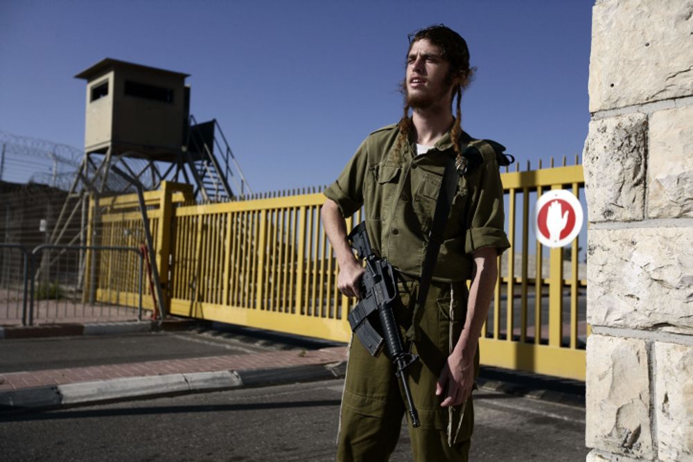 An ultra-Orthodox Jewish soldier in Israel's military guards a base near the West Bank on September 15, 2009.