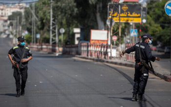 Les policiers palestiniens du Hamas portent des masques alors qu'ils surveillent une rue de la ville de Gaza, lors d'un confinement général de 48 heures, le 25 août 2020