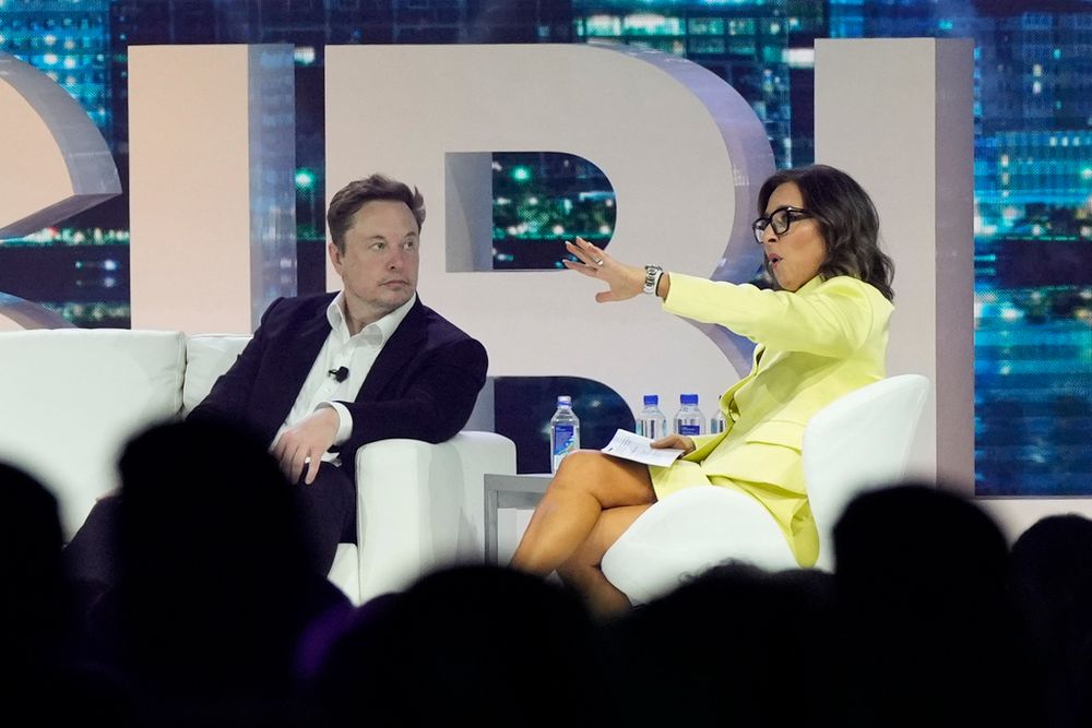 FILE - Twitter CEO Elon Musk (L) speaks with Linda Yaccarino, chairman of global advertising and partnerships for NBC, at a marketing conference in Miami Beach, Florida, U.S.