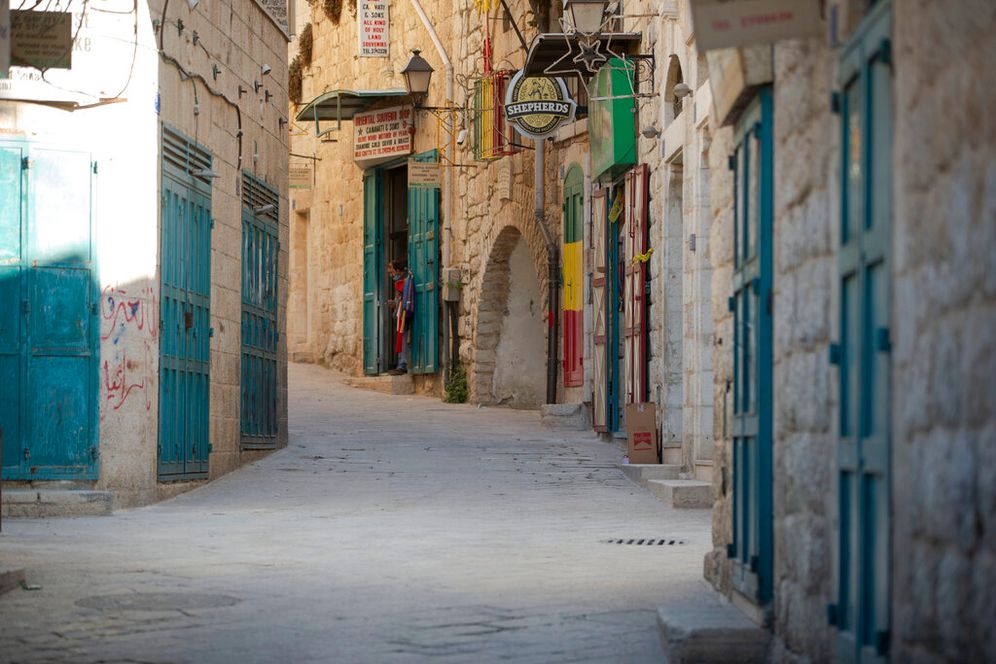 A Palestinian vendor stands in front of his shop near the Church of the Nativity, traditionally believed to be the birthplace of Jesus Christ, in the West Bank City of Bethlehem, on November 23, 2020.
