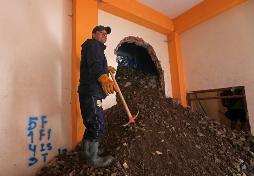 Handout photo released by the Peruvian Presidency press office shows a rescue worker at a building damaged by a landslide in Retama, Parcoy district, Peru, on March 16, 2022.
