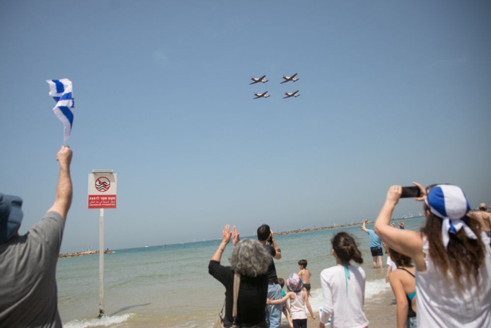 Des personnes sur la plage de Tel Aviv regardent le spectacle aérien militaire lors du 73e jour de l'indépendance d'Israël, le 15 avril 2021
