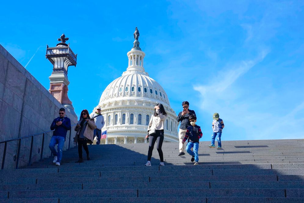 With the U.S. Capitol in the background, people walk down steps on Election Day in Washington, the United States.