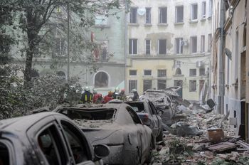 Emergency service workers gather outside damaged buildings as search for victims continues following a Russian missile attack in Lviv, Ukraine.