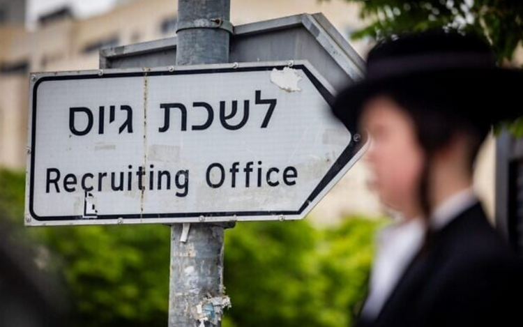 Un juif orthodoxe haredi se tient près d'un panneau indiquant un bureau de recrutement de l'armée lors d'une manifestation contre la conscription des haredim à Jérusalem, le 1er mai 2024